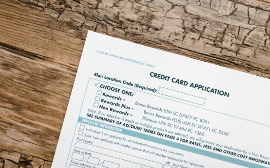 Top view of a credit card application form on rustic wooden background.